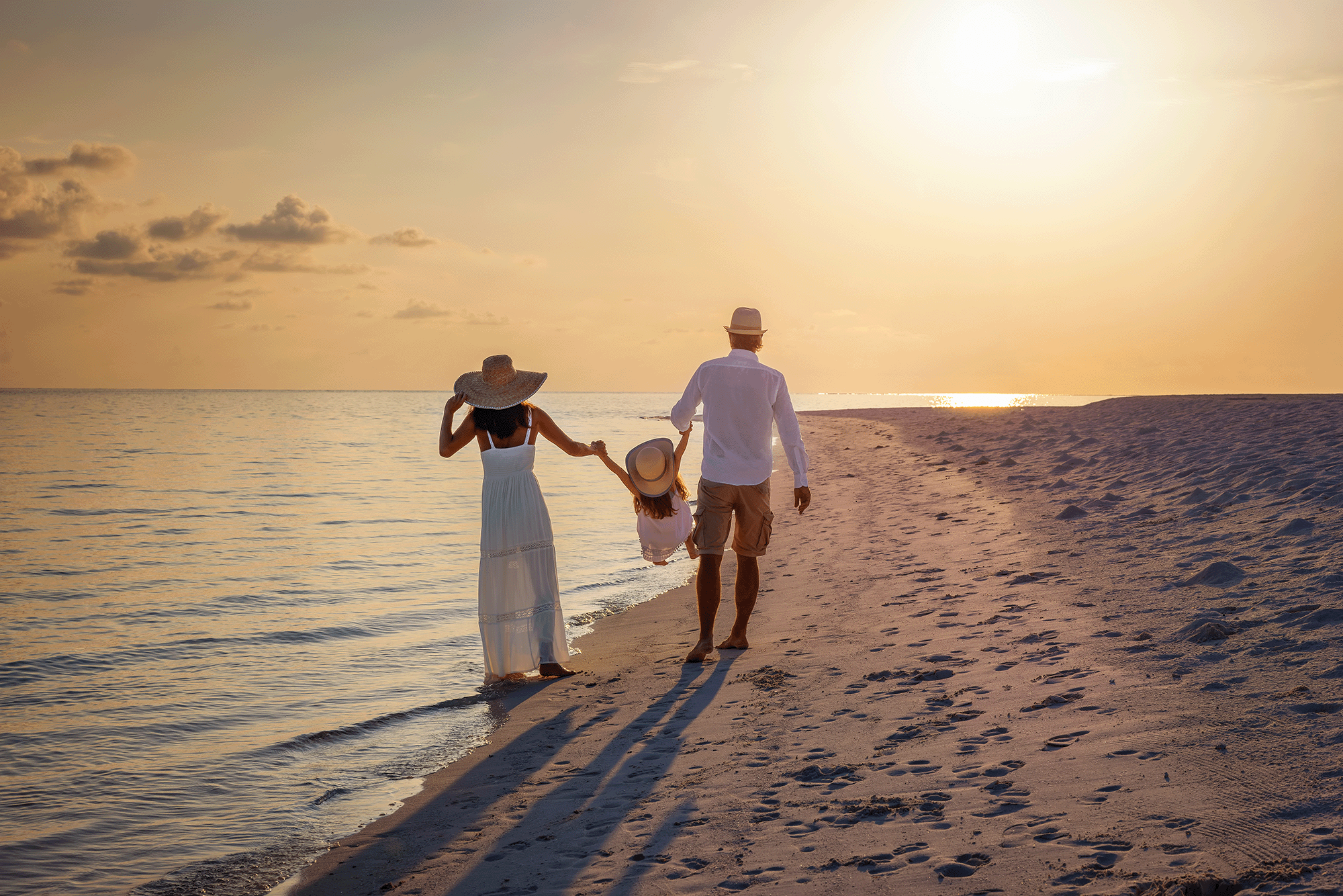 Family walking on the beach at dusk